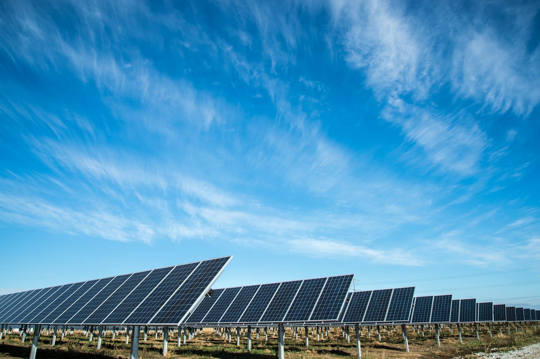 Hileras de paneles solares bajo un amplio cielo azul