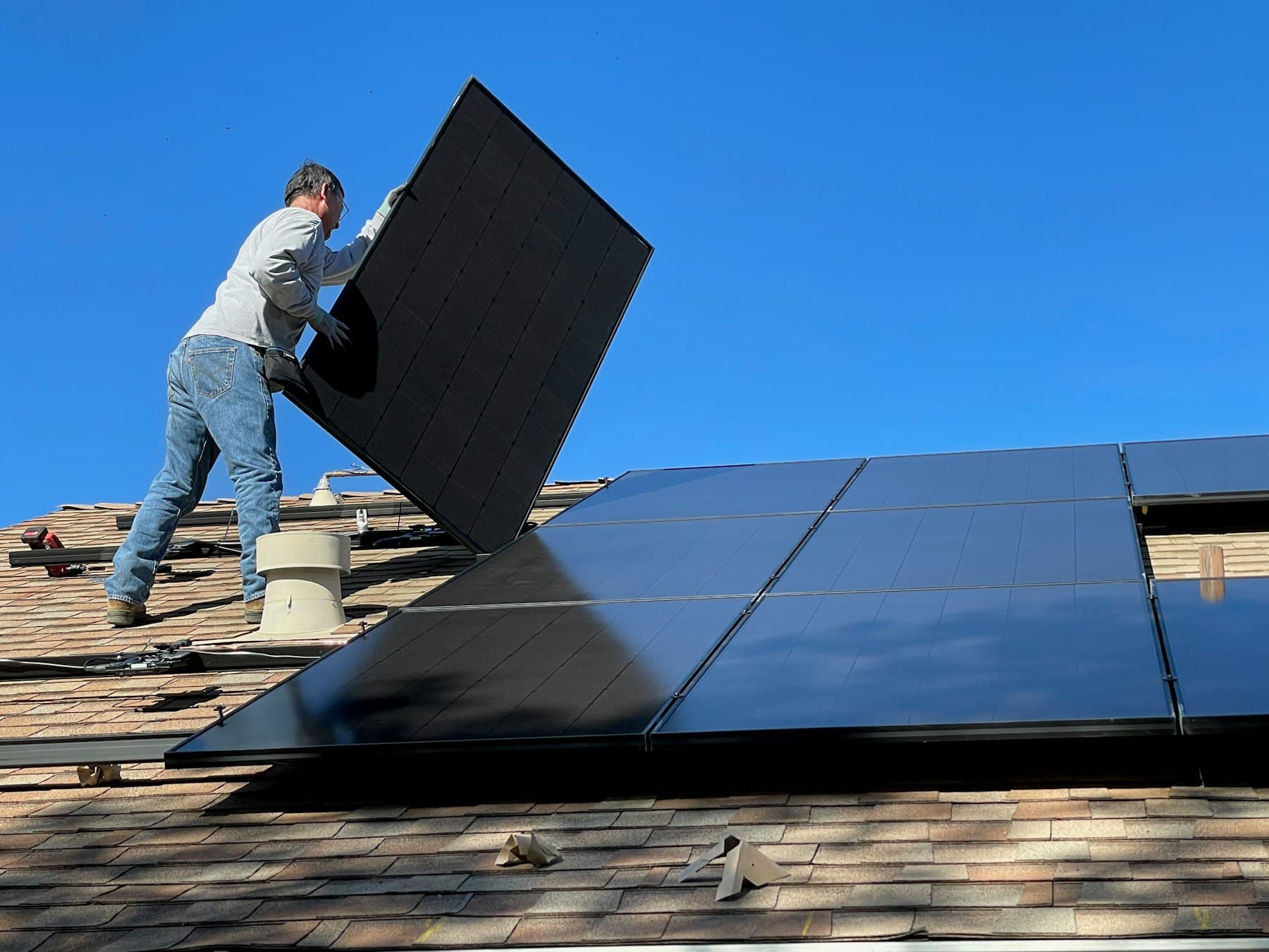 Técnico instalando un panel solar en un techo residencial
